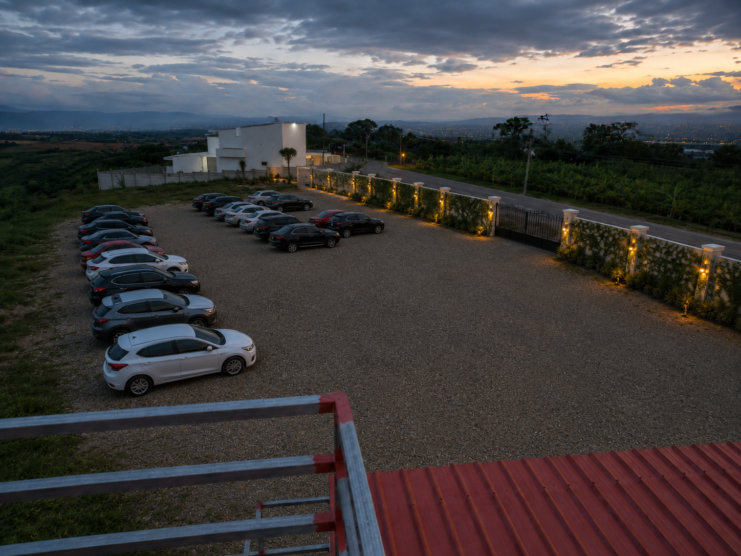 Gravel parking area at dusk with valley views and a gated entrance